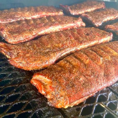 Racks of ribs sizzling on a hot grill from Pustka Family BBQ in Temple Texas